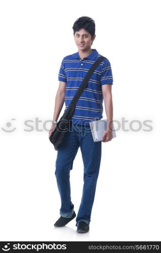 Full length portrait of confident male student with books and bag against white background