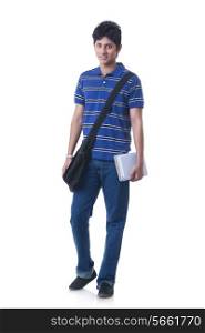 Full length portrait of confident male student with books and bag against white background