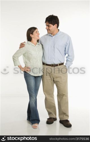 Full length portrait of couple standing smiling against white background.