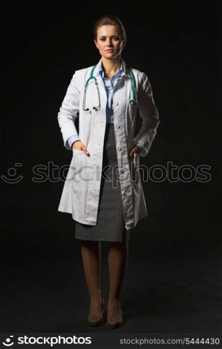 Full length portrait of doctor woman isolated on black