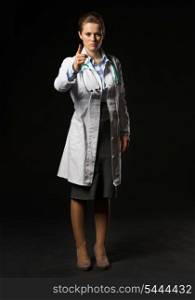 Full length portrait of doctor woman threatening with finger isolated on black