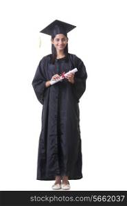 Full length portrait of female graduate student holding diploma over white background