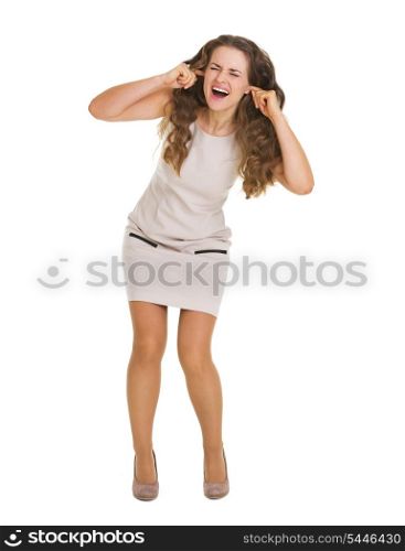Full length portrait of frustrated young woman closing ears with fingers
