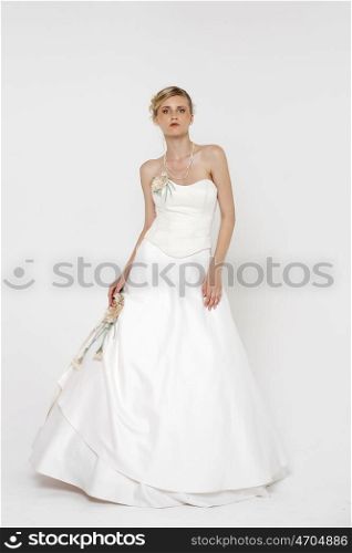 Full length portrait of gorgeous bride wearing wedding dress over grey background