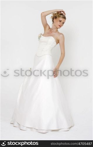 Full length portrait of gorgeous bride wearing wedding dress over grey background