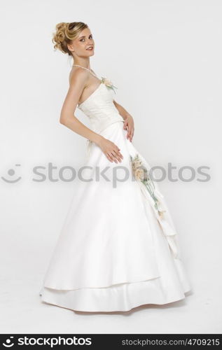 Full length portrait of gorgeous bride wearing wedding dress over grey background