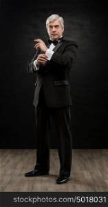 Full length portrait of handsome mature business leader over black background