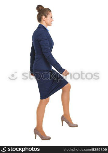 Full length portrait of happy business woman climbing the stairs