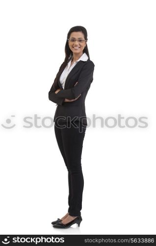 Full length portrait of happy businesswoman with arms crossed standing against white background