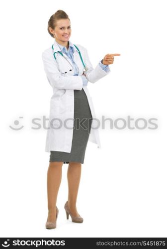 Full length portrait of happy doctor woman pointing on copy space
