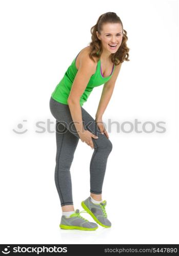 Full length portrait of happy fitness young woman checking leg muscles