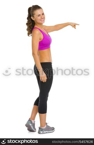 Full length portrait of happy fitness young woman pointing on copy space