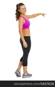 Full length portrait of happy fitness young woman pointing on copy space