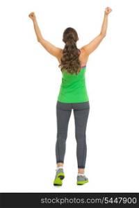 Full length portrait of happy fitness young woman rejoicing success . rear view