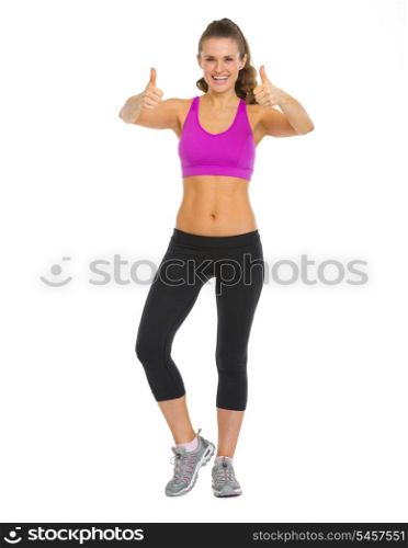Full length portrait of happy fitness young woman showing thumbs up