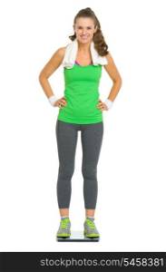 Full length portrait of happy fitness young woman standing on scales