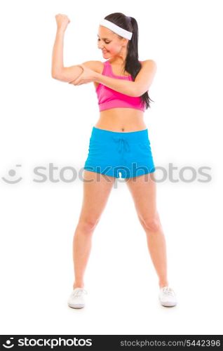 Full length portrait of happy girl in sportswear checking her muscles isolated on white&#xA;
