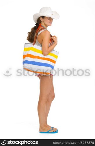 Full length portrait of happy young beach woman in hat