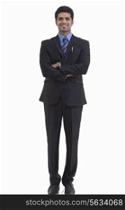 Full length portrait of happy young businessman with arms crossed standing against white background