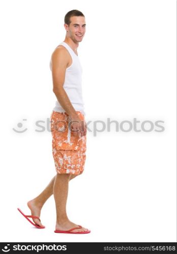 Full length portrait of happy young man going sideways