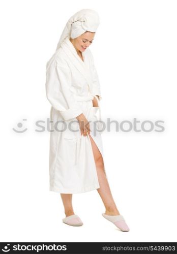 Full length portrait of happy young woman in bathrobe looking on leg
