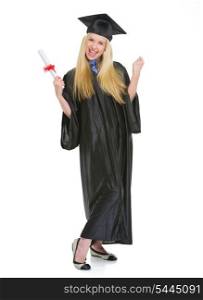Full length portrait of happy young woman in graduation gown with diploma rejoicing success
