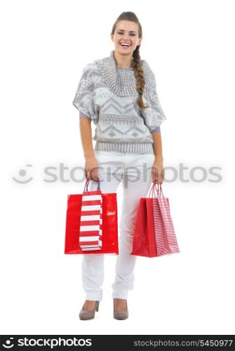 Full length portrait of happy young woman in sweater holding christmas shopping bags