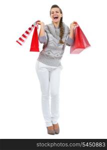 Full length portrait of happy young woman in sweater with christmas shopping bags