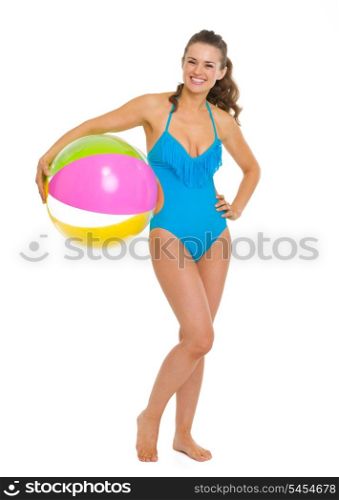 Full length portrait of happy young woman in swimsuit with beach ball