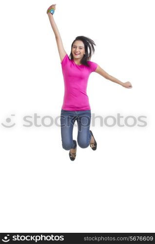 Full length portrait of happy young woman jumping over white background