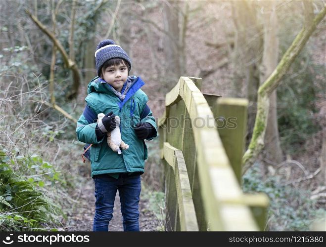 Full length Portrait of healthy boy looking at camera with smiling face, Child explorer and learning about wild nature in countryside, Kid carrying backpack adventure in forest with school trip