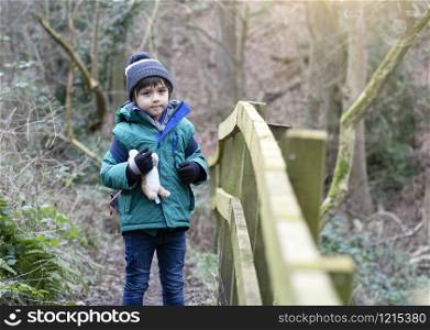 Full length Portrait of healthy boy looking at camera with smiling face, Child explorer and learning about wild nature in countryside, Kid carrying backpack adventure in forest with school trip