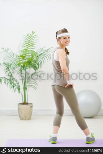 Full length portrait of healthy woman making gymnastics