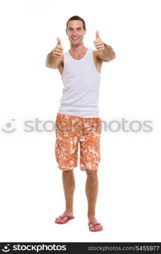 Full length portrait of resting on vacation smiling young guy showing thumbs up