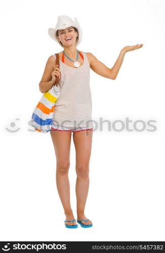 Full length portrait of smiling beach young woman presenting something on empty palm