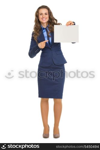 Full length portrait of smiling business woman pointing on blank billboard