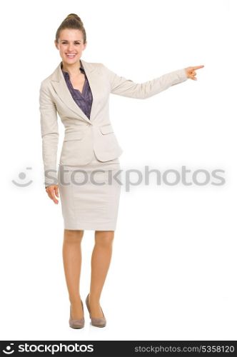 Full length portrait of smiling business woman pointing on copy space