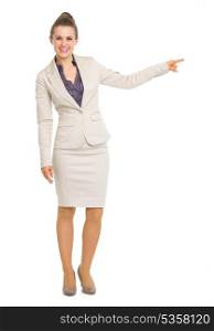 Full length portrait of smiling business woman pointing on copy space