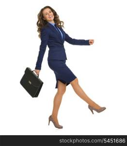 Full length portrait of smiling business woman with briefcase cheerfully going sideways