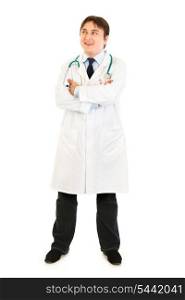 Full length portrait of smiling doctor with crossed arms on chest looking up at copy space isolated on white&#xA;