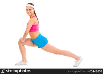 Full length portrait of smiling fitness female doing stretching exercise isolated on white&#xA;