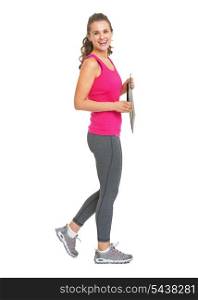 Full length portrait of smiling fitness trainer with clipboard