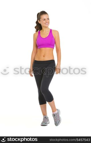 Full length portrait of smiling fitness young woman looking on copy space