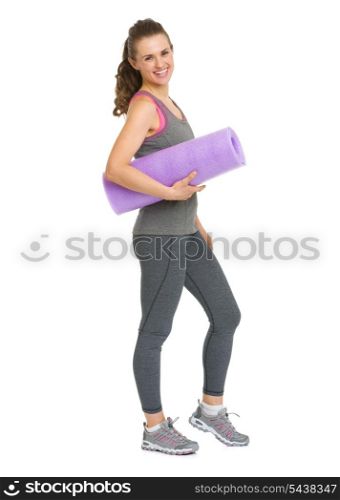 Full length portrait of smiling healthy young woman with fitness mat