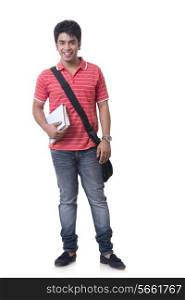 Full length portrait of smiling male student with books and bag against white background