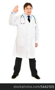 Full length portrait of smiling medical doctor showing salutation gesture isolated on white&#xA;
