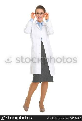 Full length portrait of smiling oculist doctor woman in eyeglasses