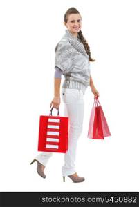 Full length portrait of smiling young woman in sweater with christmas shopping bags
