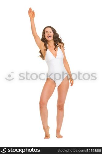 Full length portrait of smiling young woman in swimsuit greeting
