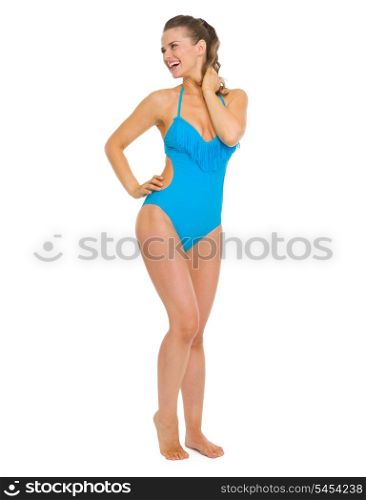 Full length portrait of smiling young woman in swimsuit looking on copy space